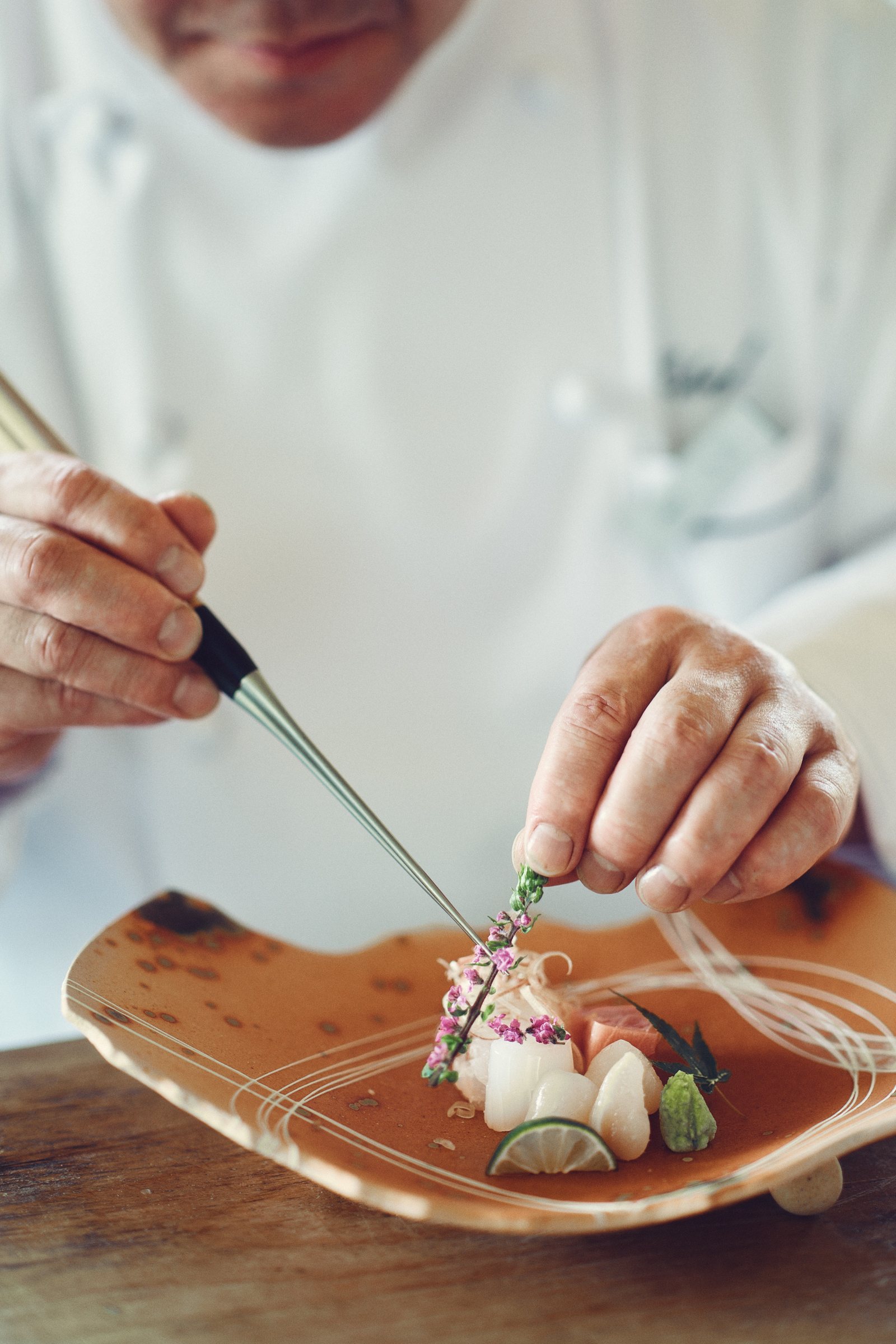 料理を盛り付ける料理人の手元